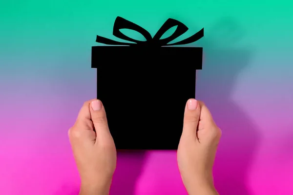 Papírový černý dárek v děloze na mnohobarevný gradient — Stock fotografie