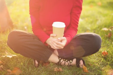 bir fincan kahve tutan genç bir kadın