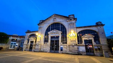 Akşamları tipik bir Fransız belediye pazarı manzarası. Fenerler ve Fransız bayrağının renginde bayraklar. Haziran 01, 2025. Soulac sur Mer, Fransa.