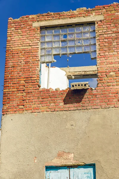 Vieja pared de ladrillo rojo. Shabby antigua pared de la casa con ventanas rotas. Peligro de colapso del edificio de emergencia. Un hogar en ruinas . — Foto de Stock