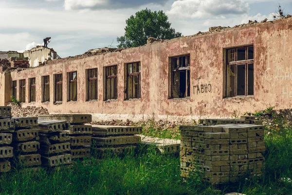 Vieja pared de ladrillo rojo. Shabby antigua pared de la casa con ventanas rotas. Peligro de colapso del edificio de emergencia. Un hogar en ruinas . — Foto de Stock