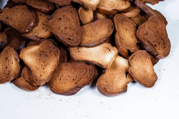 A textura de pedaços de pão torrado. Croutons em um fundo branco. Pão seco escuro. — Fotografia de Stock