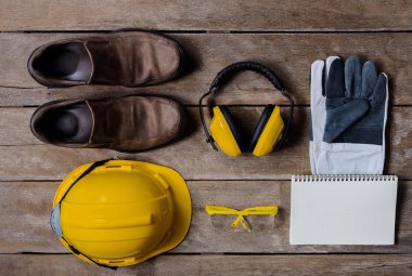 Standart inşaat güvenlik ekipmanları ve eski ahşap arka plan üstünde boş defter. Üstten Görünüm, Emanet ilk kavramlar