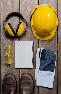 Standart inşaat güvenlik ekipmanları ve eski ahşap arka plan üstünde boş defter. Üstten Görünüm, Emanet ilk kavramlar