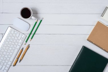 Kahve, defter, kalem, bilgisayar klavye fare üstünde o ile ahşap beyaz ofis resepsiyon masası. Kopya alanı ile Üstten Görünüm