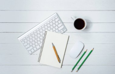 Kahve, defter, kalem, bilgisayar klavye fare üstünde o ile ahşap beyaz ofis resepsiyon masası. Kopya alanı ile Üstten Görünüm