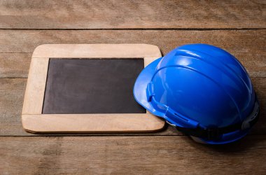 Eski ahşap arka plan kara tahta ile mavi koruyucu güvenlik kask. Emanet ilk kavramlar