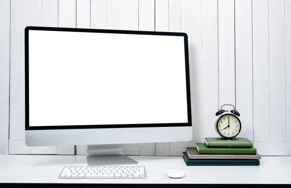 workplace background for designers with Blank white screen modern desktop computer, keyboard, book, alarm clock White wooden vintage background