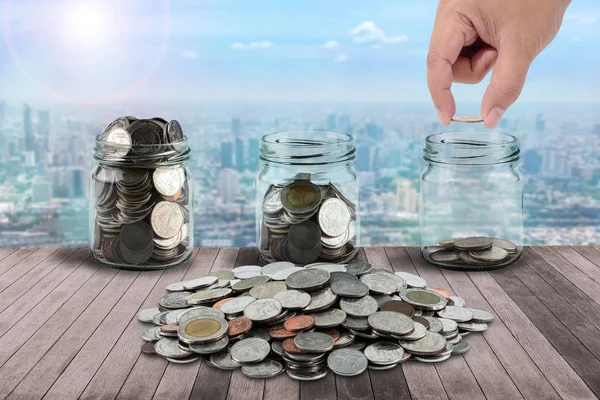 Male Hand Putting Money Coins Clear Bottle Wooden Plank Green — Stock Photo, Image