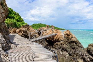 Ahşap geçit, kayalık sahil ve beyaz kum plaj mavi deniz ile Kohkham. Sattahip, Chonburi, Tayland, Thailand