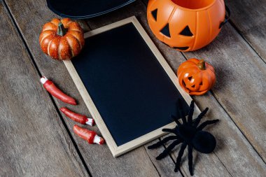 Halloween Pumpkins, cadı şapkası, Siyah örümcek ve ahşap zemin üzerinde boş yazı tahtası ile arka plan. yukarıdan görüntülemek