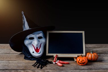 Cadılar Bayramı arka plan. Halloween Pumpkins, Siyah örümcek, ahşap zemin ve siyah arka plan üzerinde cadı maskesi Ayaklıklı kara tahta