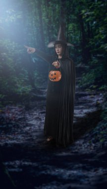 Karanlık bir orman ay ışığında içinde siyah korkunç cadı halloween kılık Holding Cadılar Bayramı Balkabağı kadın portresi