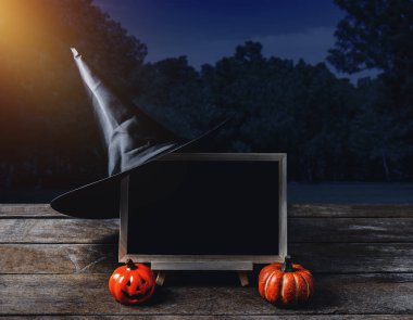 Cadılar Bayramı arka plan. Ürkütücü kabak, cadı şapka, kara tahta ay ve karanlık orman ile ahşap zemin üzerinde. Cadılar Bayramı tasarımı ile boşaltmak