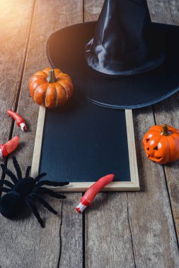 Halloween Pumpkins, cadı şapkası, Siyah örümcek ve ahşap zemin üzerinde boş yazı tahtası ile arka plan. yukarıdan görüntülemek