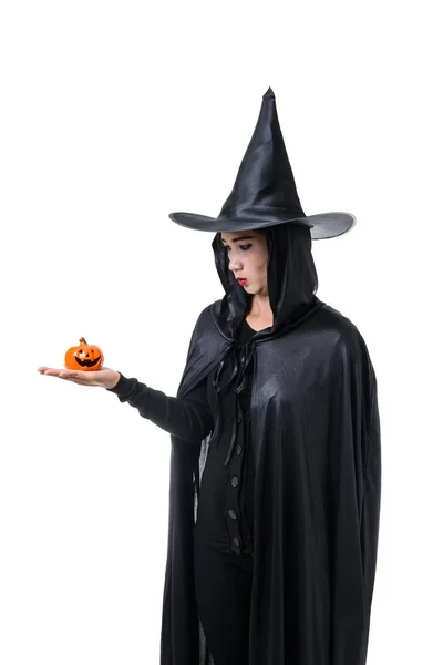 在黑色可怕的女巫万圣节服装的肖像站在帽子和持有一个南瓜孤立的白色背景与修剪路径 — 图库照片