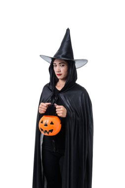 Portre siyah korku içinde kadın cadı şapka ile ayakta ve kırpma yolu ile beyaz arka plan üzerinde izole bir kabak tutan halloween kılık