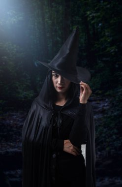 Portre siyah korku içinde kadın cadı halloween kılık ile karanlık bir orman ay ışığında