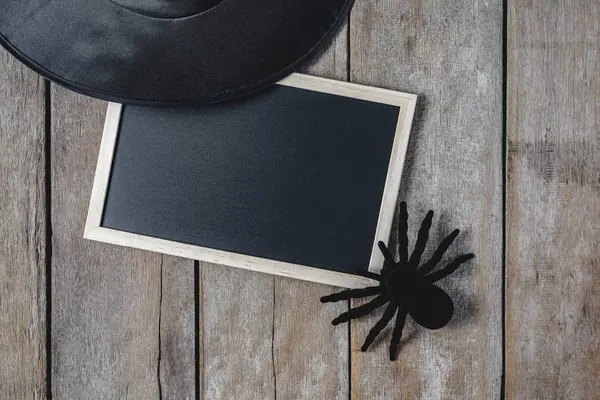 万圣节背景与女巫帽子 黑蜘蛛和空黑板在木地板上 从上面查看 — 图库照片