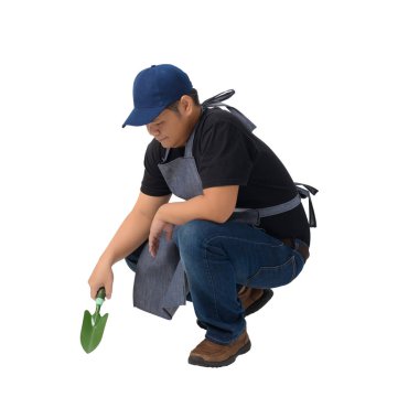 çalışan adam ya da asker oturan ve beyaz arka plan kırpma yolu üzerinde izole Kültivatörler için kürek tutan önlük ile siyah gömlekli. El yapımı, DIY, Bahçe kavramı