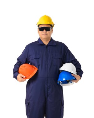 Makinist tulum holding kask beyaz arka plan kırpma yolu üzerinde izole koruyucu gözlük ile çok renkli bir işçi portresi