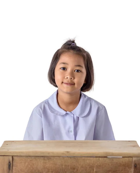 クリッピング パスと白い背景で隔離の木製テーブルと制服でアジアの少女の肖像画 — ストック写真
