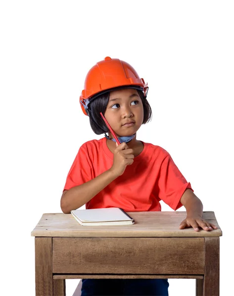 亚洲儿童戴着安全帽 用铅笔思考刨花 笔记书隔离在白色背景与剪裁路径 儿童和教育理念 — 图库照片