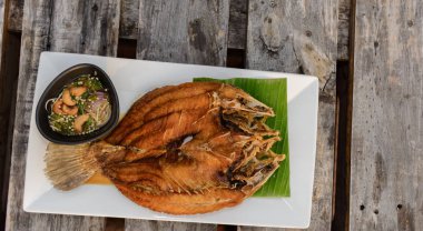 Derin kızarmış Snapper ahşap masanın üstüne tatlı balık sosu ile tepesinde. Üstten görünüm