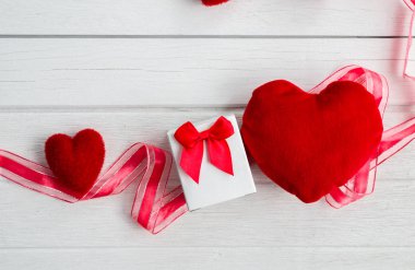 Sevgiliye arka plan ile kalp şekli, hediye kutusu ve şerit Beyaz ahşap masa üzerinde