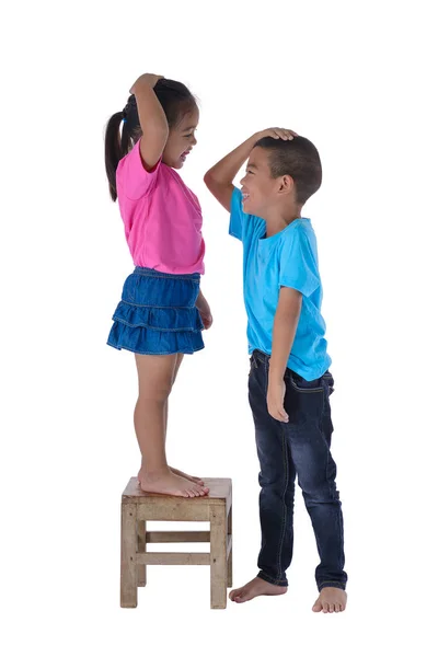 Küçük erkek ve kız beyaz bac izole onların yükseklik ölçme — Stok fotoğraf