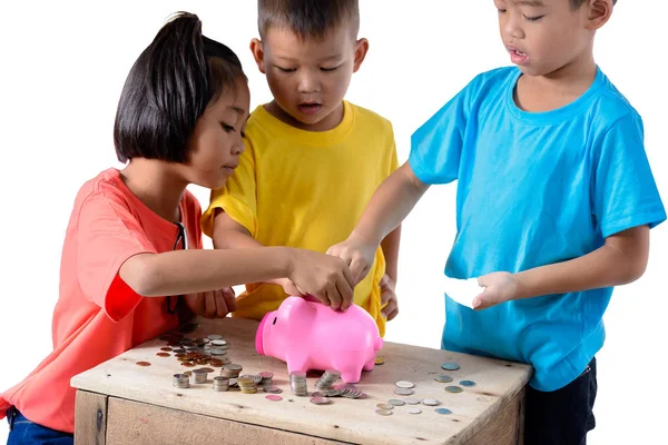 Group of asian children are helping putting coins into piggy ban Stock Photo