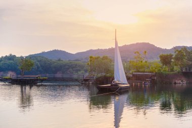 Yelkenli büyük bir rezervuar içinde arka plan olarak dağlar var