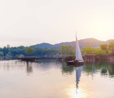 Yelkenli büyük bir rezervuar içinde arka plan olarak dağlar var