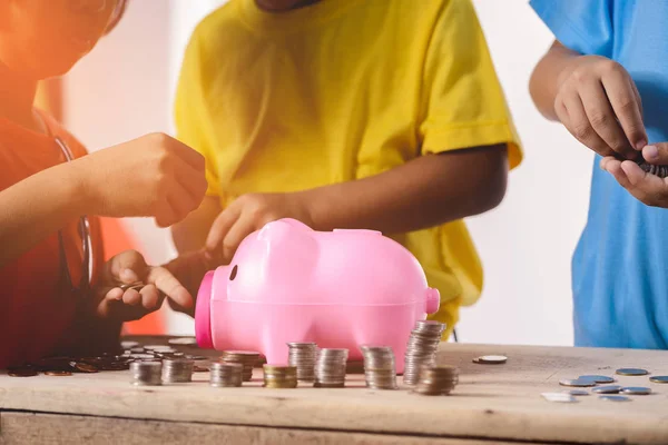 Çocukların kumbara w üzerinde içine para koyarak yardımcı elleriz — Stok fotoğraf