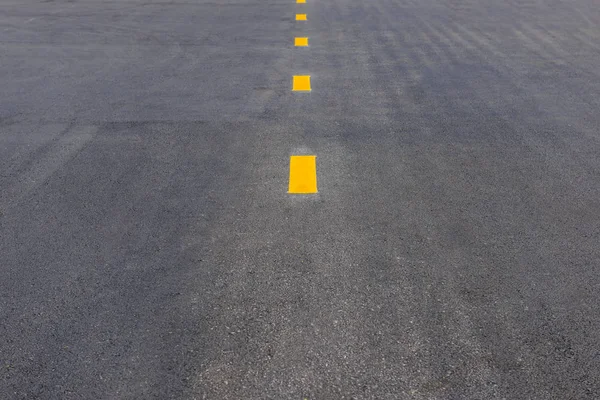 Línea amarilla de puntos para carril roto en carretera asfaltada, señalización vial — Foto de Stock