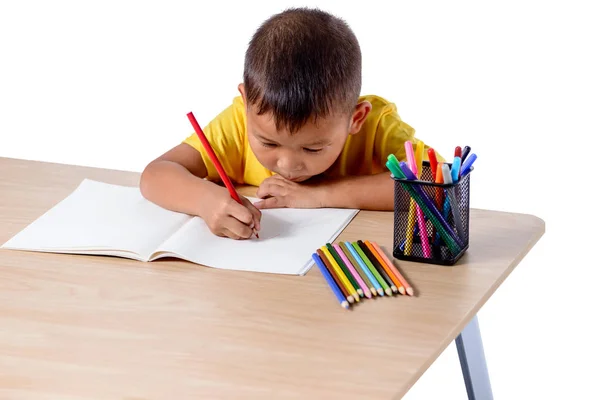Lindo dibujo alegre niño usando lápiz de color mientras está sentado en —  Fotos de Stock