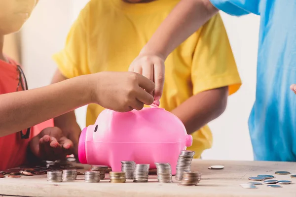 Çocukların kumbara w üzerinde içine para koyarak yardımcı elleriz — Stok fotoğraf