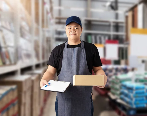 Male staff Delivering products Sign the signature on the product receipt form with parcel boxes Blurred the background of the warehouse