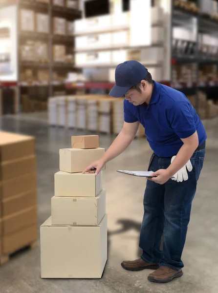 Male staff and parcel boxes checking stock or Preparing Goods For Dispatch and Blurred the background of the warehouse