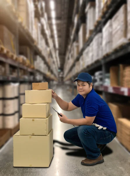 Male staff and parcel boxes checking stock or Preparing Goods For Dispatch and Blurred the background of the warehouse