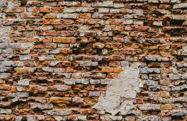 コンクリートで割れたスタッコの層の背景を持つ古い遺跡レンガの壁 — ストック写真