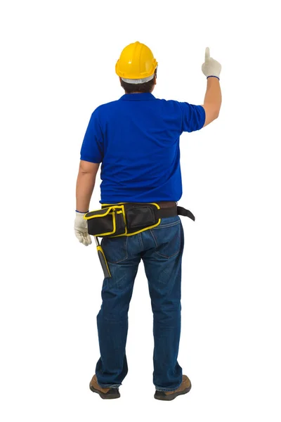バックビュー保護手袋付きブルーシャツの建設男の労働者 ツールベルトと指でヘルメットクリッピングパスと白の背景に隔離された上を指す — ストック写真