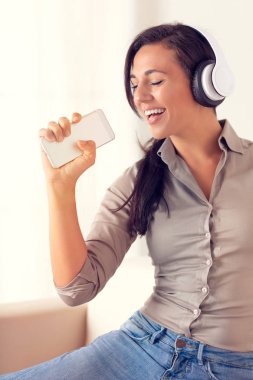 Şarkı ve müzik bir kanepede kulaklıklarla kadın portresi