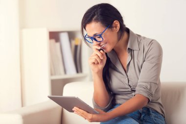 Evde bir kanepede oturan digialt tablet kullanma neşeli kadın portresi