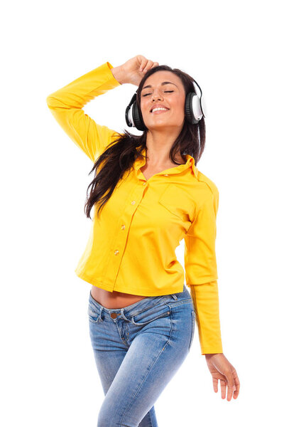 Happy young woman listening to music on stereo headphones with closed eyes and a beaming smile of pleasure isolated on white
