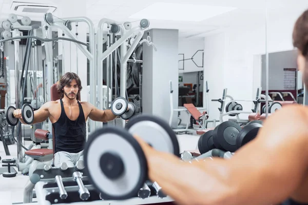 Bodybuilder Der Einem Fitnessstudio Auf Einer Bank Sitzt Und Hantelgewichte — Stockfoto