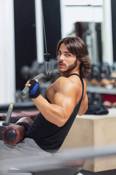 Fit Adult Bodybuilder Pulling Bar Attached Cable Weightlifting Machine While — Stock Photo, Image