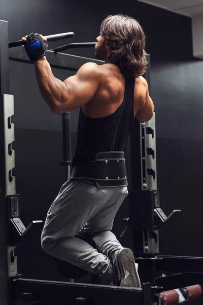 运动肌肉的人在健身房做拉 Ups 从后方观看 以加强他的肌肉 — 图库照片