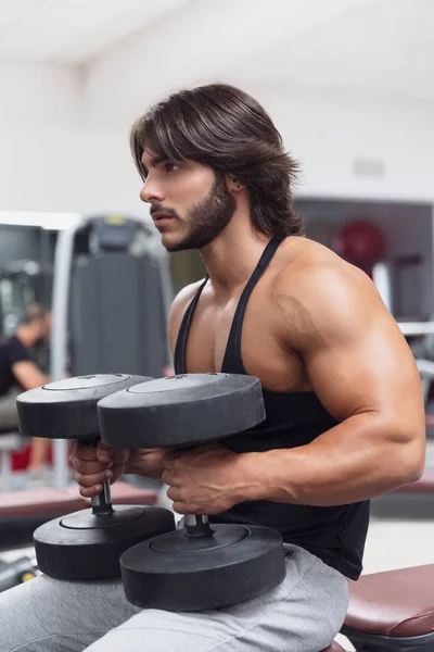 Bodybuilder Der Einem Fitnessstudio Auf Einer Bank Sitzt Und Hantelgewichte — Stockfoto