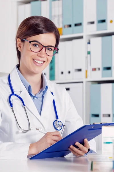 Sonriendo Amigable Joven Doctora Enfermera Usando Estetoscopio Escribiendo Notas Portapapeles —  Fotos de Stock